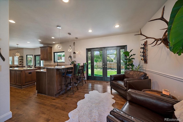 10701 Flagler Dr, Parker, CO 80134 - kitchen featuring french doors, a breakfast bar, a peninsula, dark wood-style floors, and recessed lighting