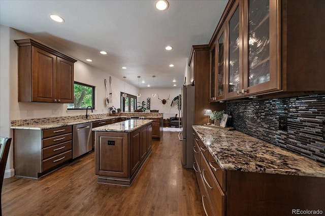 10701 Flagler Dr, Parker, CO 80134 - kitchen with stainless steel appliances, a peninsula, a center island, recessed lighting, and backsplash