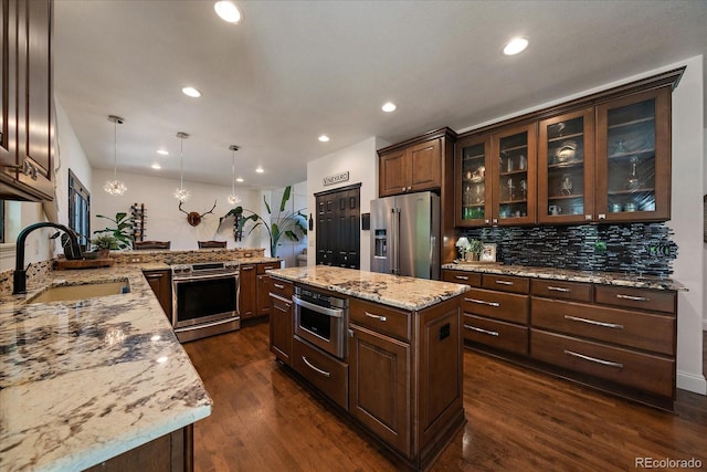 10701 Flagler Dr, Parker, CO 80134 - kitchen featuring appliances with stainless steel finishes, a sink, decorative backsplash, dark brown cabinets, and recessed lighting