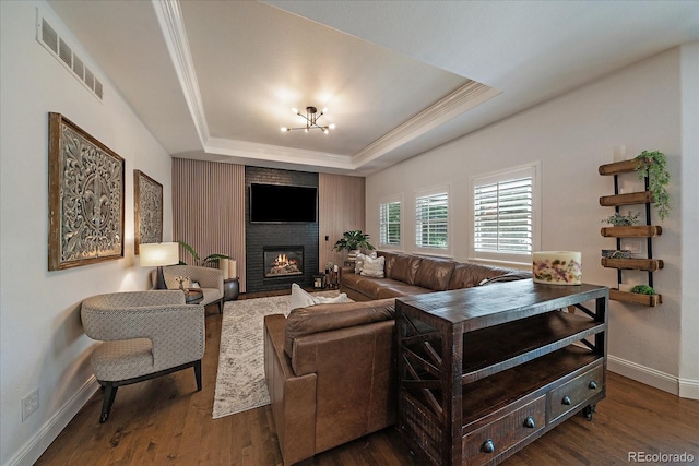 10701 Flagler Dr, Parker, CO 80134 - living area with baseboards, a raised ceiling, crown molding, dark wood finished floors, and a large fireplace