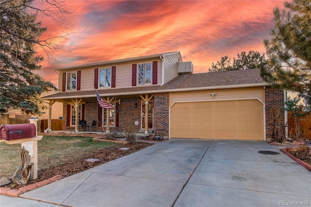 traditional-style home featuring a garage, covered porch, driveway, and brick siding