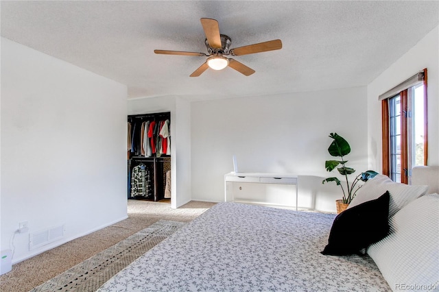 bedroom with a closet, visible vents, a ceiling fan, carpet flooring, and a textured ceiling