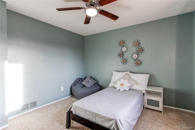 bedroom featuring carpet floors, baseboards, visible vents, and a ceiling fan