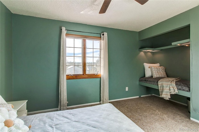 carpeted bedroom featuring ceiling fan, a textured ceiling, and baseboards