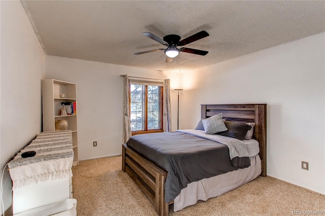 bedroom with light carpet, ceiling fan, and a textured ceiling