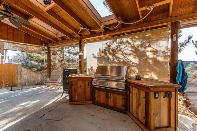 view of patio / terrace featuring a ceiling fan, fence, grilling area, and an outdoor kitchen