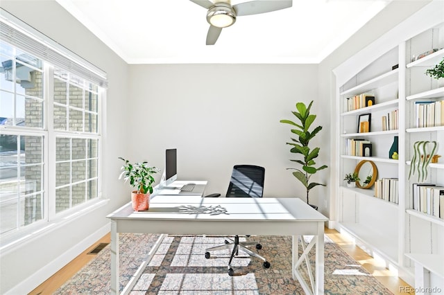 office area with hardwood / wood-style flooring, ornamental molding, built in features, and ceiling fan