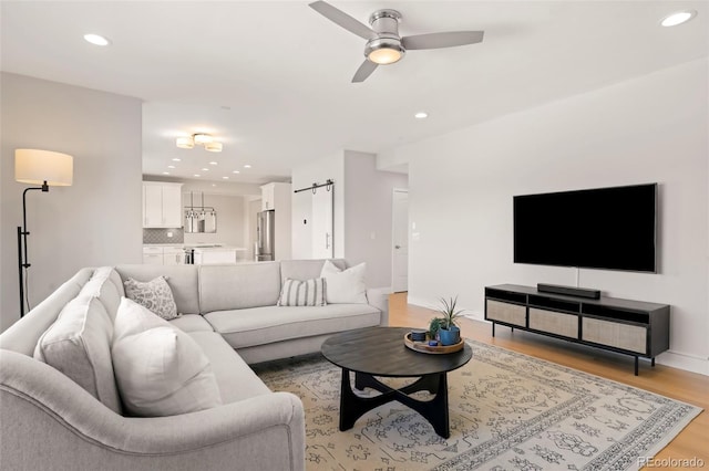 living room with light hardwood / wood-style flooring and ceiling fan