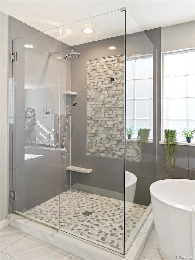 bathroom featuring shower with separate bathtub