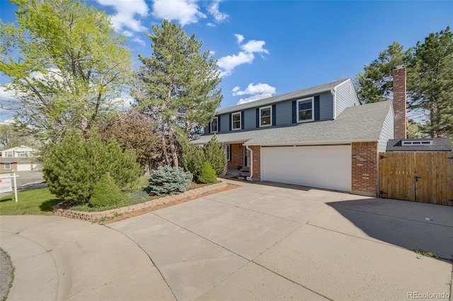 9926 W Nova Pl, Littleton, CO 80127 - traditional-style home featuring concrete driveway, brick siding, a chimney, a gate, and a shingled roof
