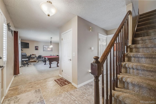 9926 W Nova Pl, Littleton, CO 80127 - foyer featuring billiards table, stairway, a textured ceiling, and light colored carpet
