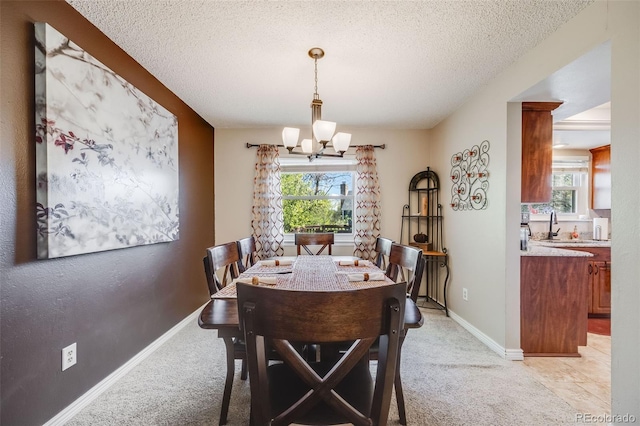 9926 W Nova Pl, Littleton, CO 80127 - dining space featuring a chandelier, a textured ceiling, and light carpet