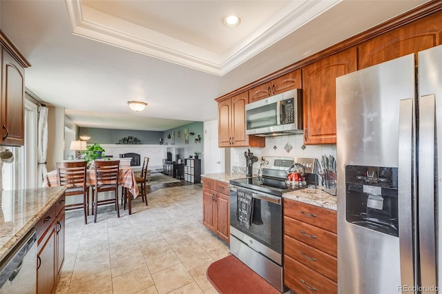 9926 W Nova Pl, Littleton, CO 80127 - kitchen featuring stainless steel appliances, light stone countertops, crown molding, a tray ceiling, and brown cabinets