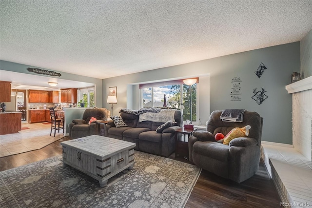 9926 W Nova Pl, Littleton, CO 80127 - living area featuring light wood-style flooring, a textured ceiling, and a fireplace