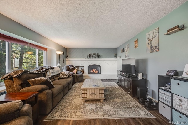 9926 W Nova Pl, Littleton, CO 80127 - living room featuring dark wood finished floors, a textured ceiling, and a lit fireplace