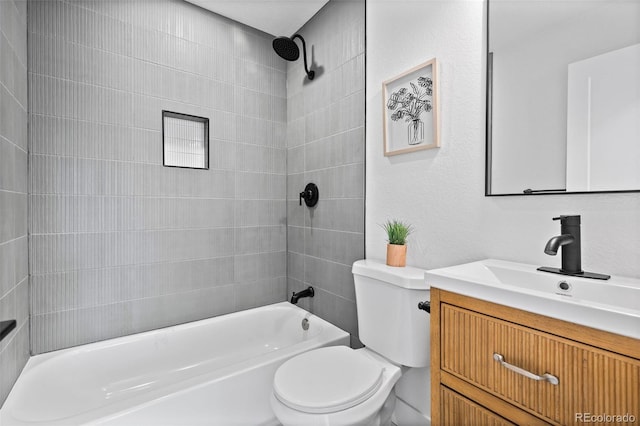 full bathroom featuring tiled shower / bath combo, vanity, and toilet