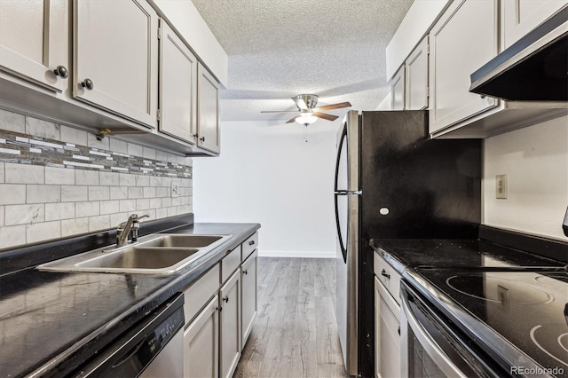 kitchen featuring sink, ceiling fan, stainless steel appliances, a textured ceiling, and light wood-type flooring