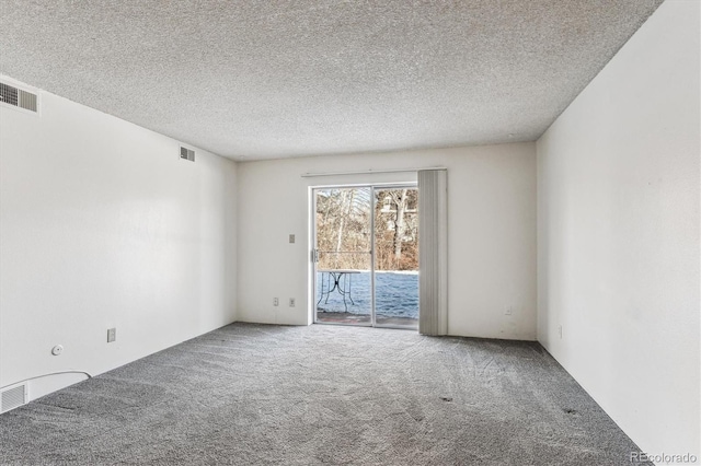 carpeted empty room featuring a textured ceiling