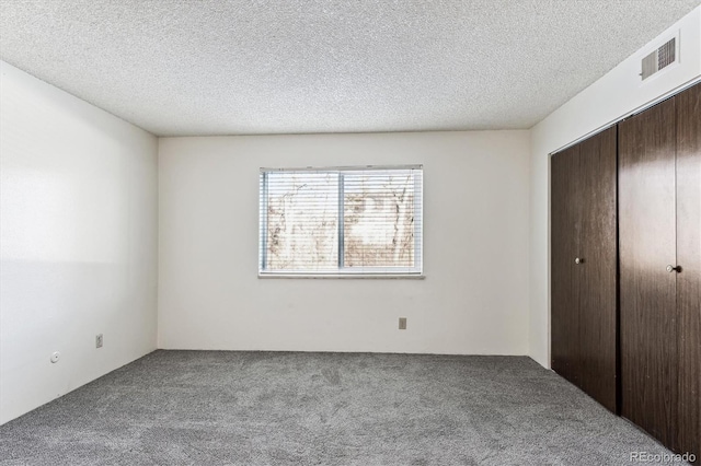 unfurnished bedroom with a closet, carpet, and a textured ceiling