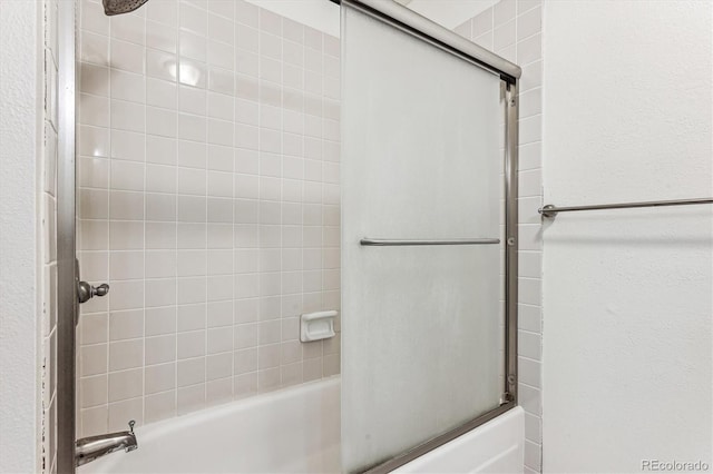 bathroom with bath / shower combo with glass door