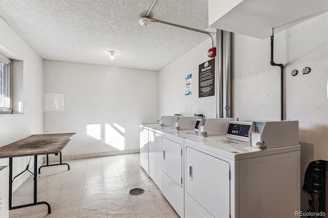 clothes washing area featuring washing machine and dryer and a textured ceiling