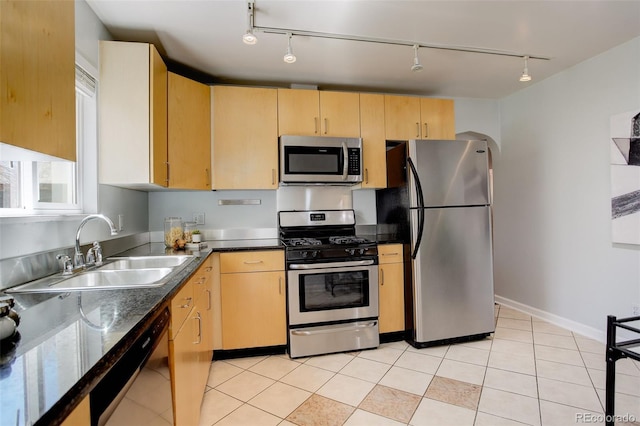kitchen featuring light brown cabinets, appliances with stainless steel finishes, light tile patterned floors, and a sink