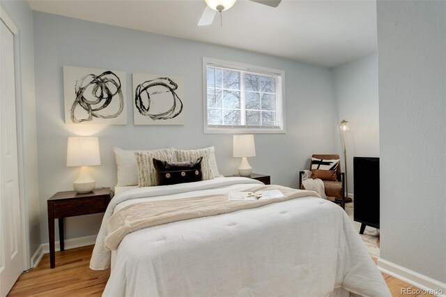 bedroom with light wood-style floors, baseboards, and ceiling fan