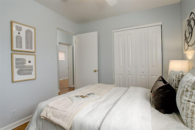 bedroom with a closet, wood finished floors, and baseboards