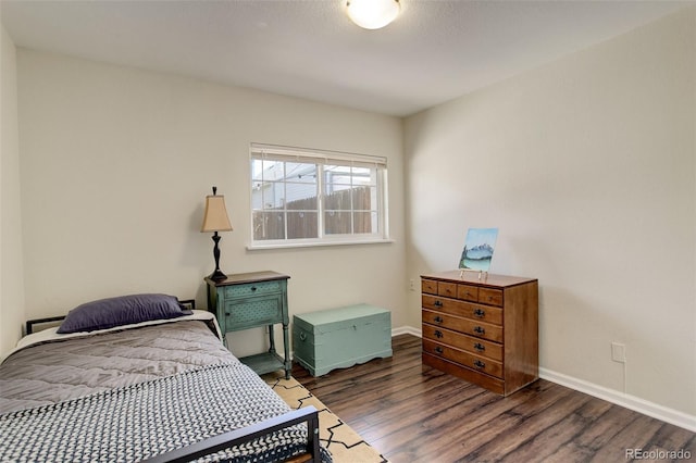 bedroom featuring baseboards and wood finished floors