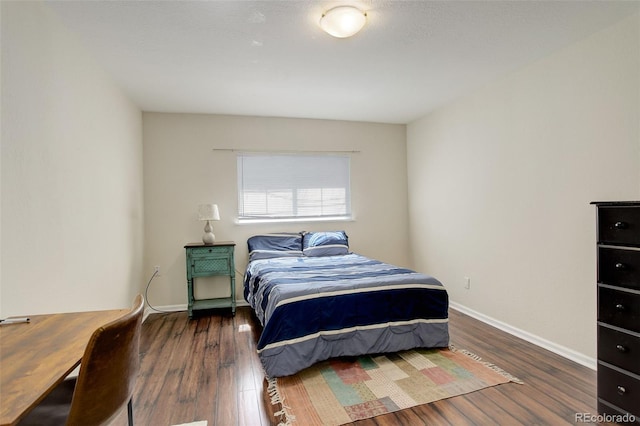 bedroom featuring wood finished floors and baseboards