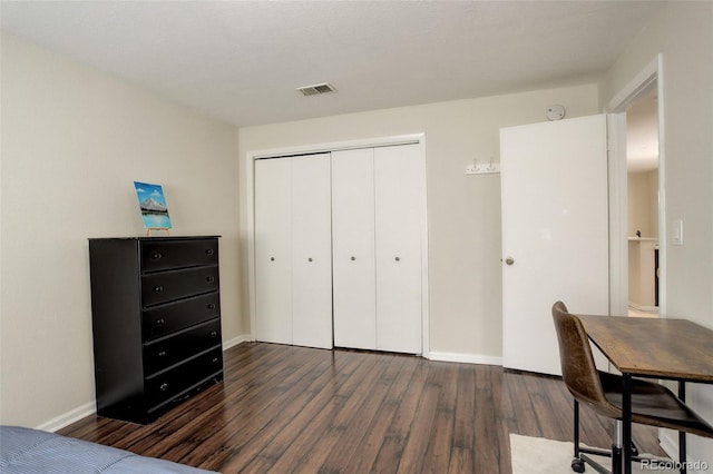 bedroom featuring a closet, visible vents, baseboards, and wood finished floors
