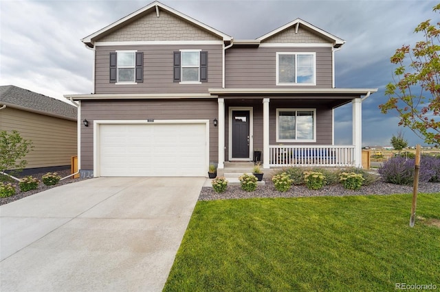 view of front of home with covered porch, a front lawn, and a garage