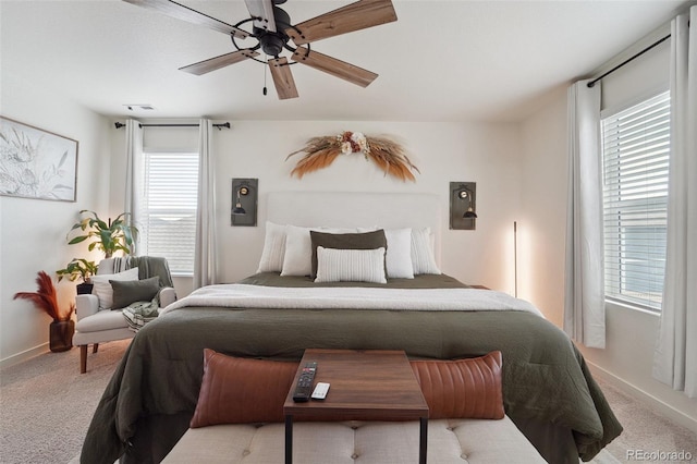 bedroom featuring multiple windows, light carpet, and ceiling fan