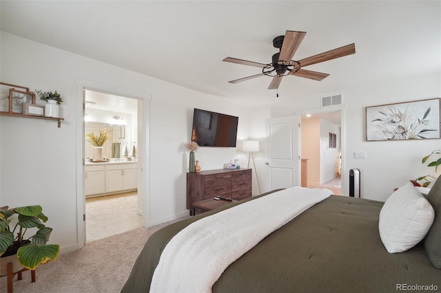 bedroom featuring ensuite bathroom, ceiling fan, and light colored carpet