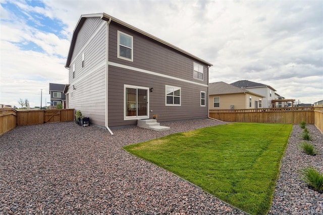 rear view of property featuring a lawn