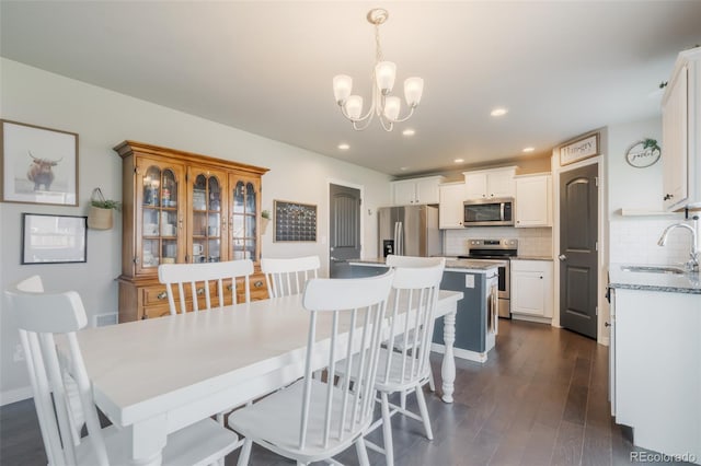 dining room featuring dark hardwood / wood-style floors, sink, and a chandelier