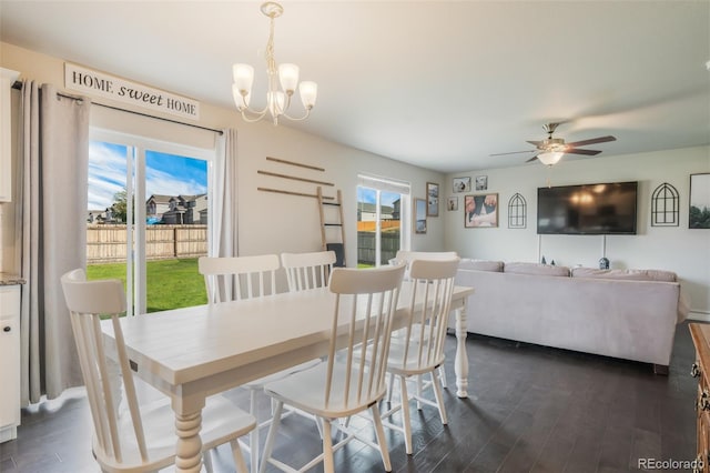 dining space with ceiling fan with notable chandelier and dark wood-type flooring