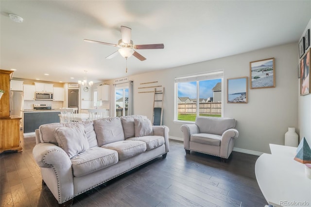 living room featuring ceiling fan with notable chandelier and dark hardwood / wood-style floors