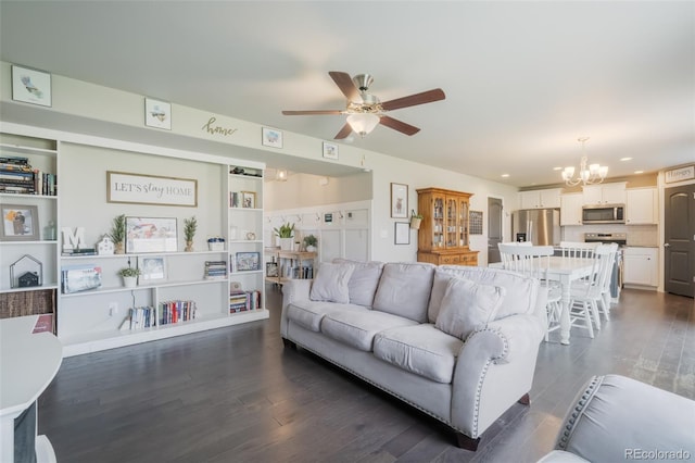 living room featuring ceiling fan with notable chandelier and dark hardwood / wood-style flooring