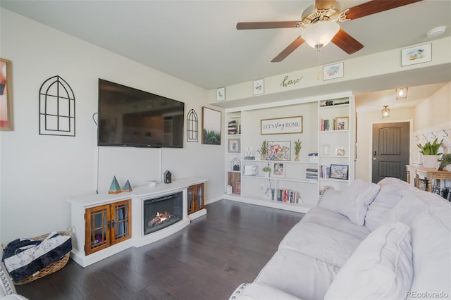 living room featuring ceiling fan and dark wood-type flooring