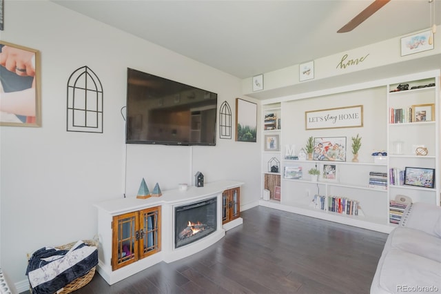 living room featuring ceiling fan and dark wood-type flooring