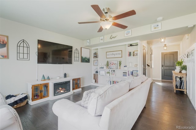 living room featuring ceiling fan and dark wood-type flooring