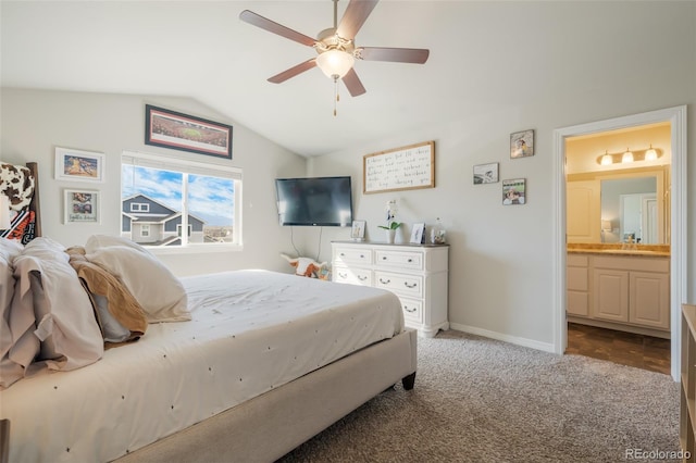 carpeted bedroom featuring vaulted ceiling, ceiling fan, ensuite bath, and sink