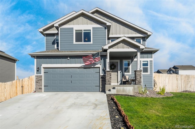 craftsman inspired home with a garage and a front lawn