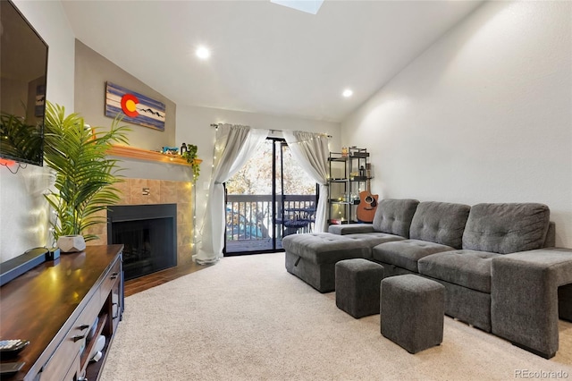 living room featuring lofted ceiling and a tiled fireplace