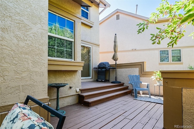 wooden deck featuring a grill