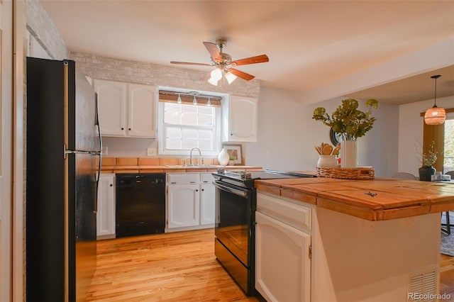 kitchen featuring white cabinets, hanging light fixtures, ceiling fan, black appliances, and light hardwood / wood-style floors