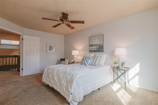 bedroom featuring multiple windows, ceiling fan, a textured ceiling, carpet floors, and a skylight