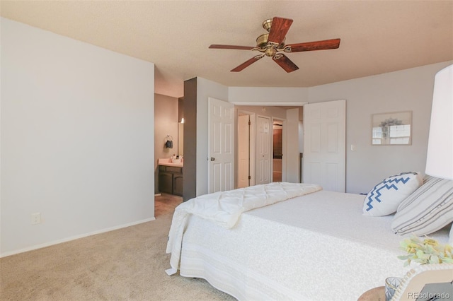 bedroom with connected bathroom, ceiling fan, and light carpet