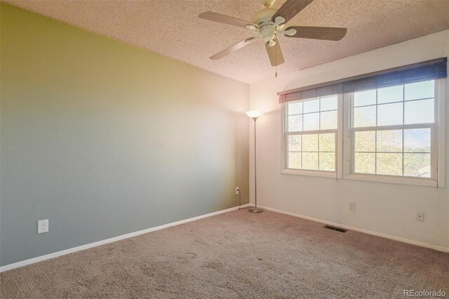 carpeted spare room featuring a textured ceiling and ceiling fan